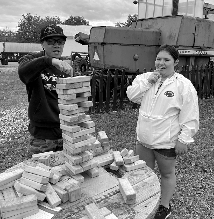 Andres and Hannah play a game of giant jenga at the Farm.